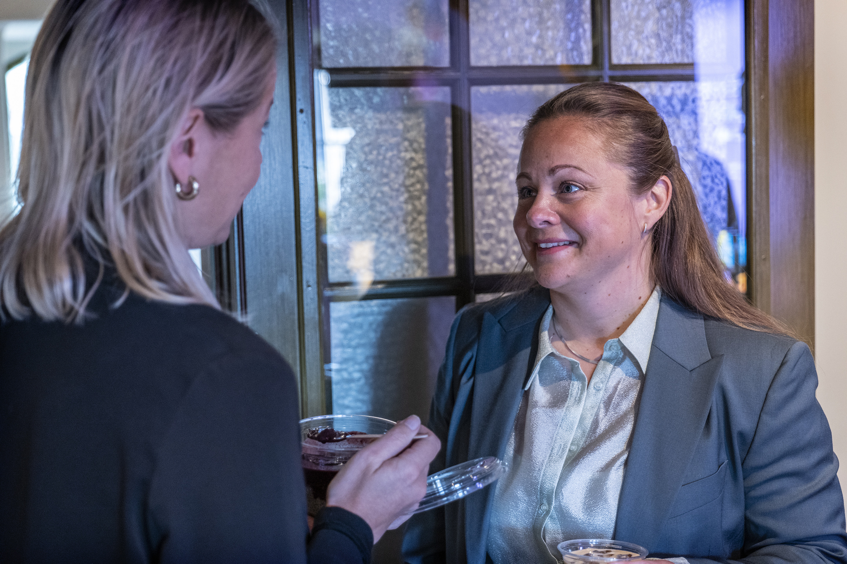 En kvinna som pratar med en annan kvinna p&aring; en fest.