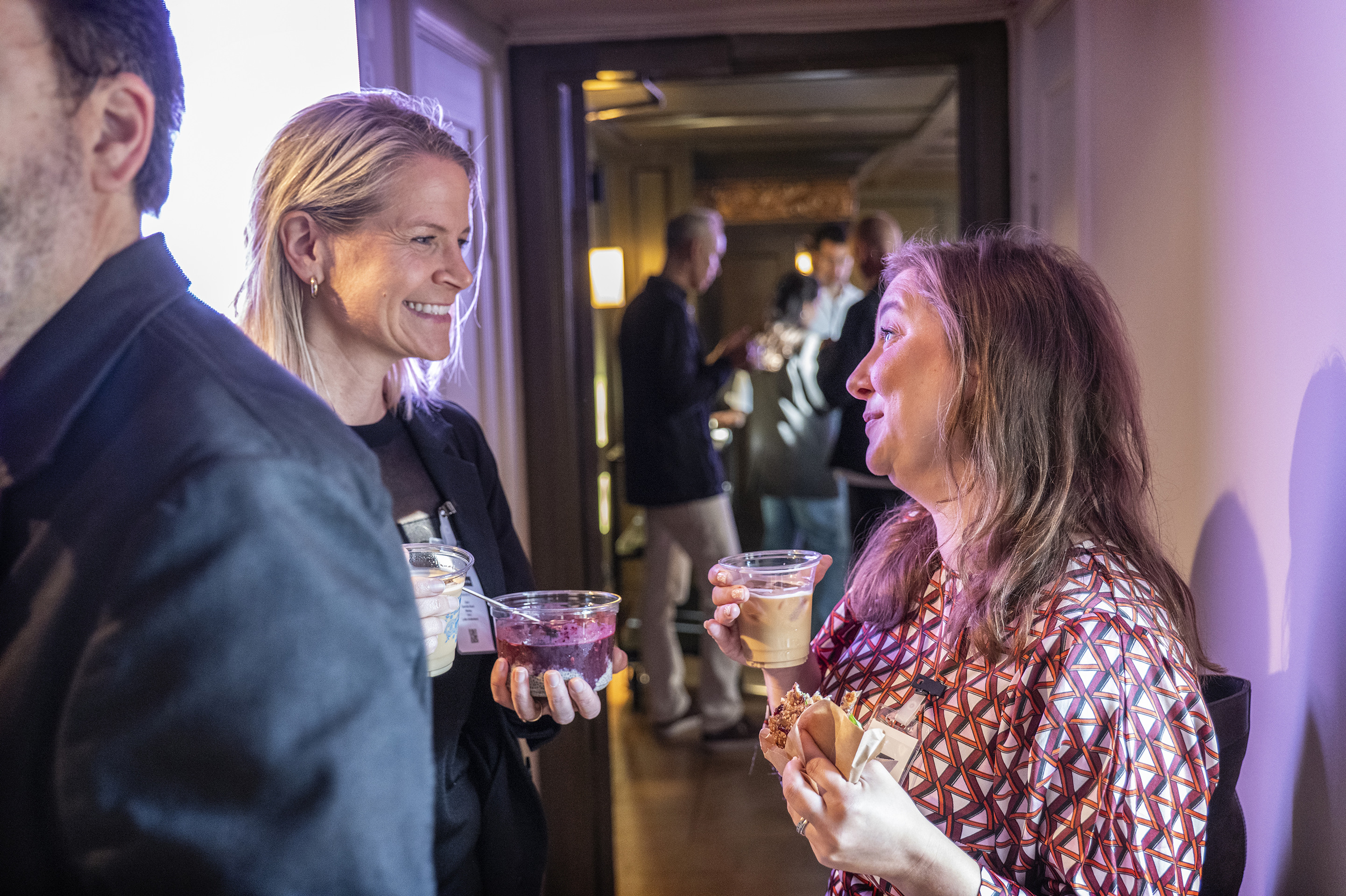 En grupp m&auml;nniskor som st&aring;r bredvid varandra och h&aring;ller i sina drinkar.