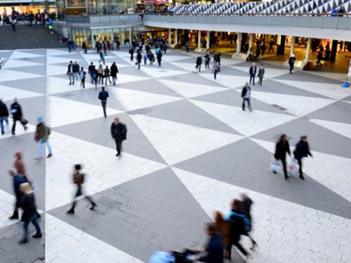 En grupp människor som går runt i ett köpcentrum.