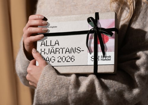 En kvinna som håller i en låda med en namnbricka på.