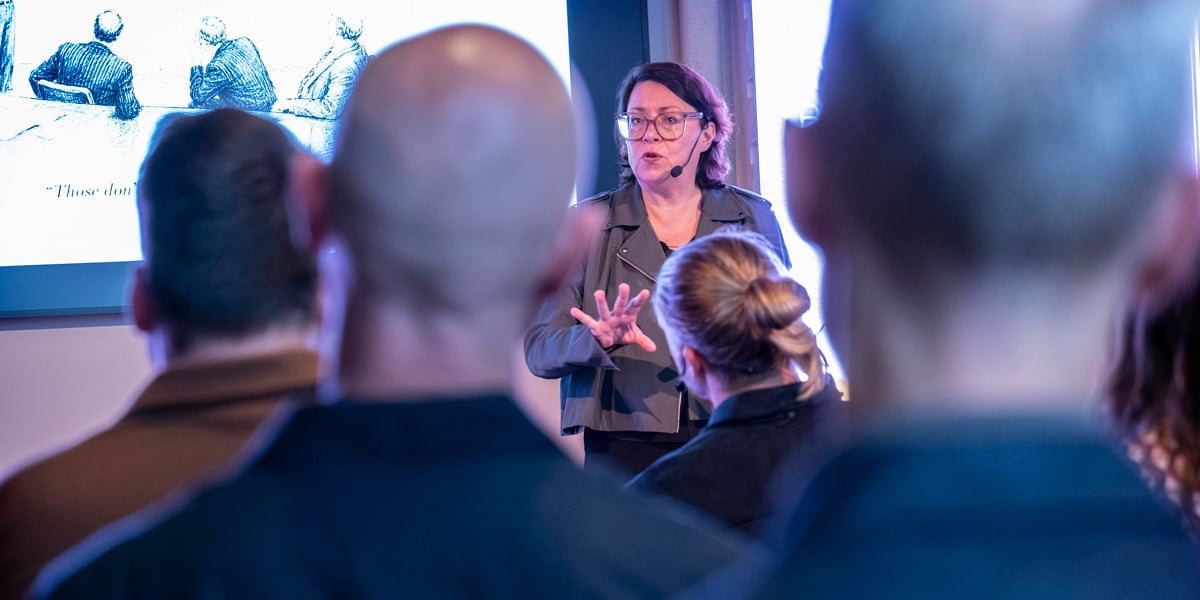 En kvinna som står framför en grupp människor.