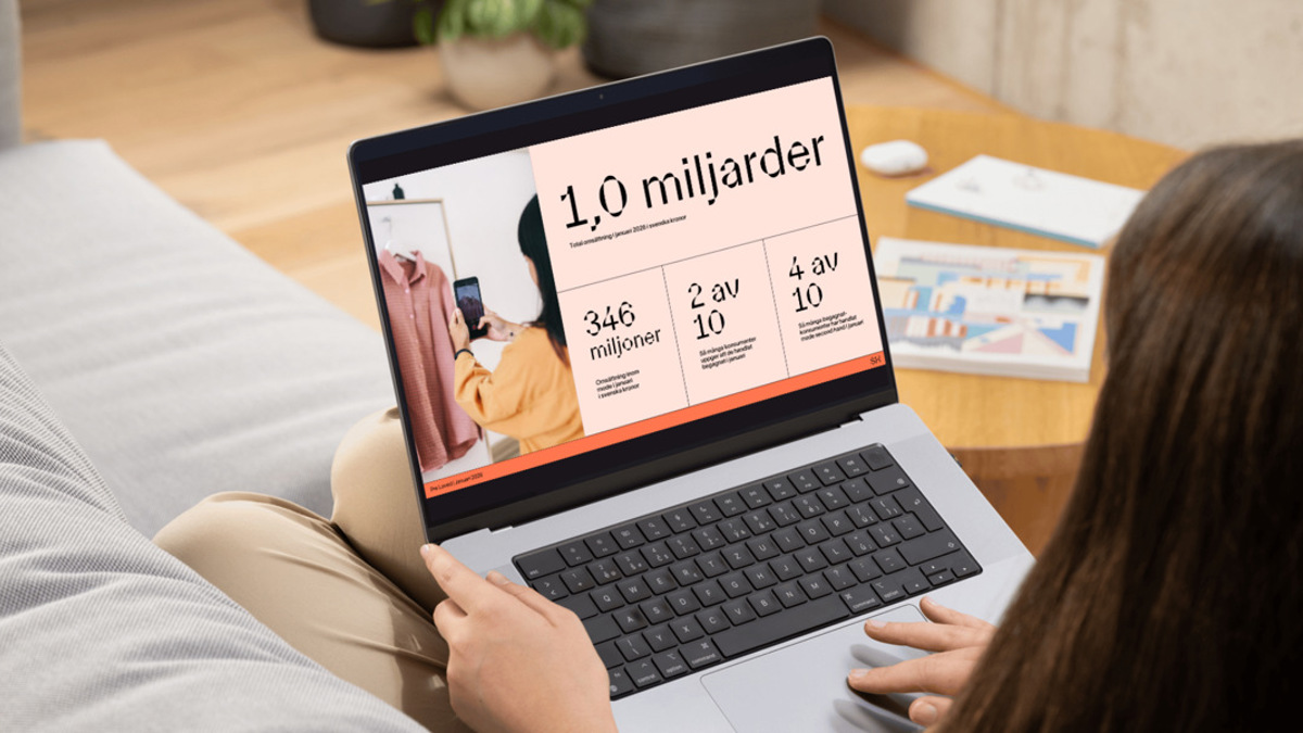 En kvinna sitter i en soffa och använder en bärbar dator.