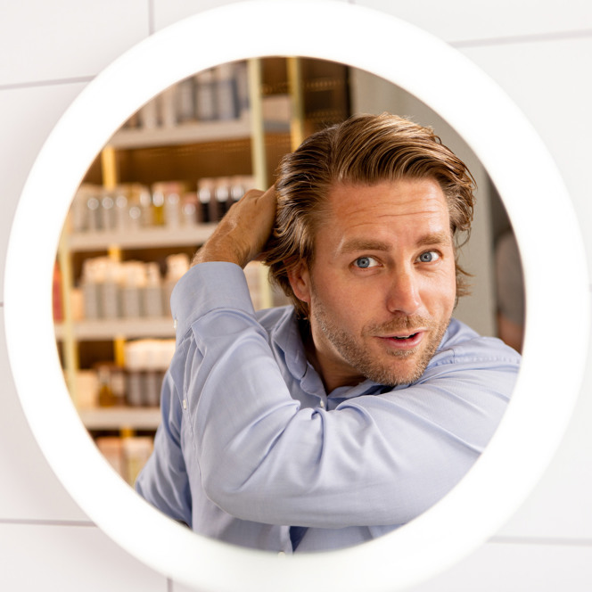 En man som tittar på sig själv i spegeln.