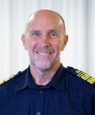 En man i uniform som ler mot kameran.