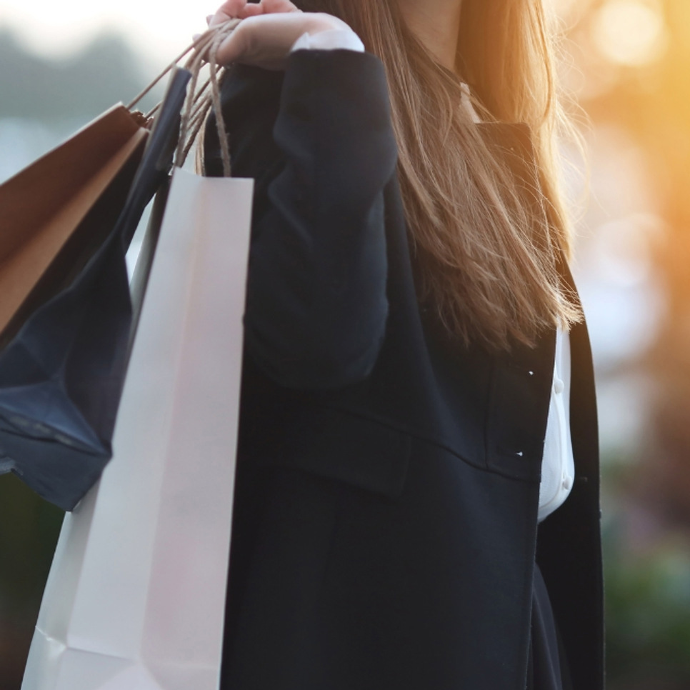 En kvinna med shoppingkassar i händerna.