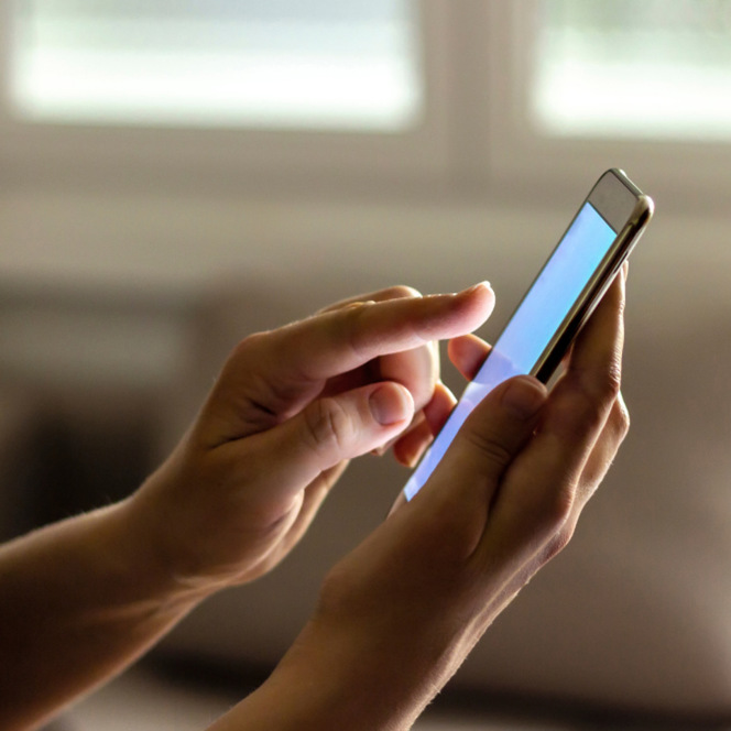 En person som håller en smart telefon i handen.