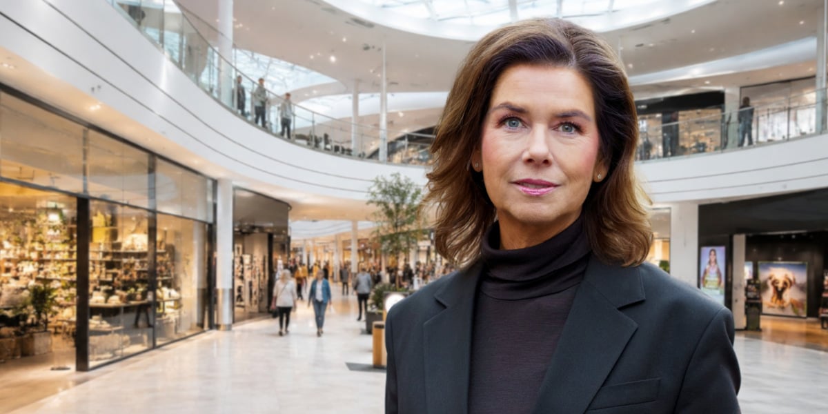 En kvinna som står i ett köpcentrum och tittar in i kameran.