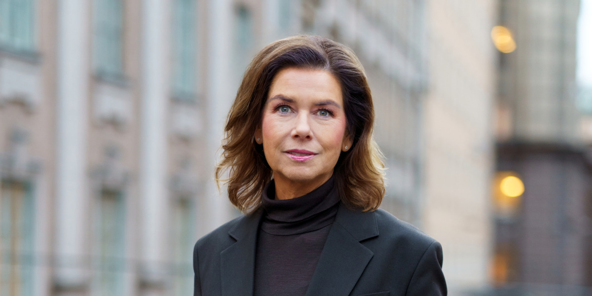 En kvinna som bär svart kostym och svarta skor.