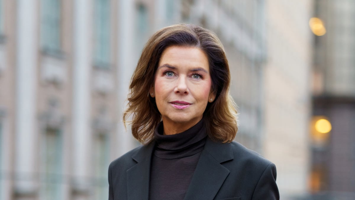 En kvinna som bär svart kostym och svarta skor.