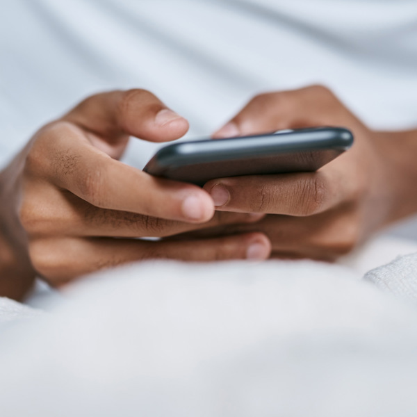 En närbild på en person som håller i en mobiltelefon.