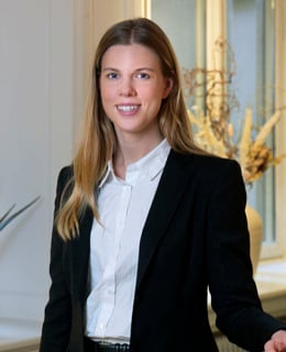 En kvinna som står framför ett fönster.