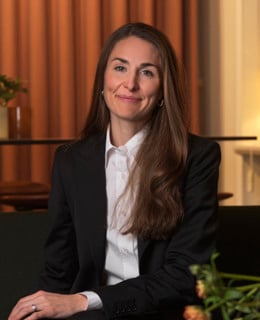 En kvinna sitter på en soffa i ett rum.