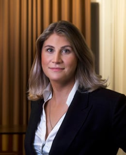 En kvinna står framför ett träbord.