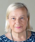 En kvinna med blont hår som bär en blå tröja.
