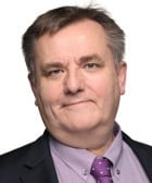 En man i kostym och slips som poserar för ett foto.