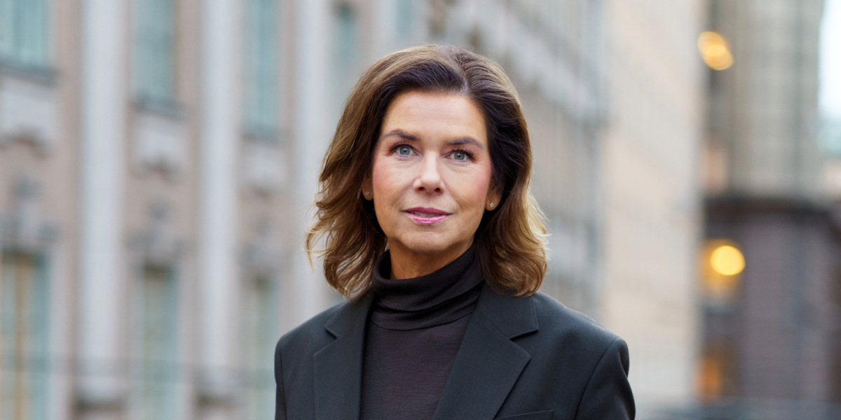 En kvinna som bär svart kostym och svarta skor.
