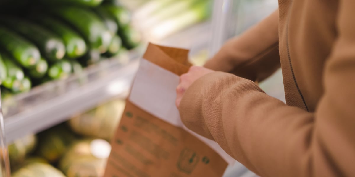 En person som håller i ett papper i en livsmedelsbutik.