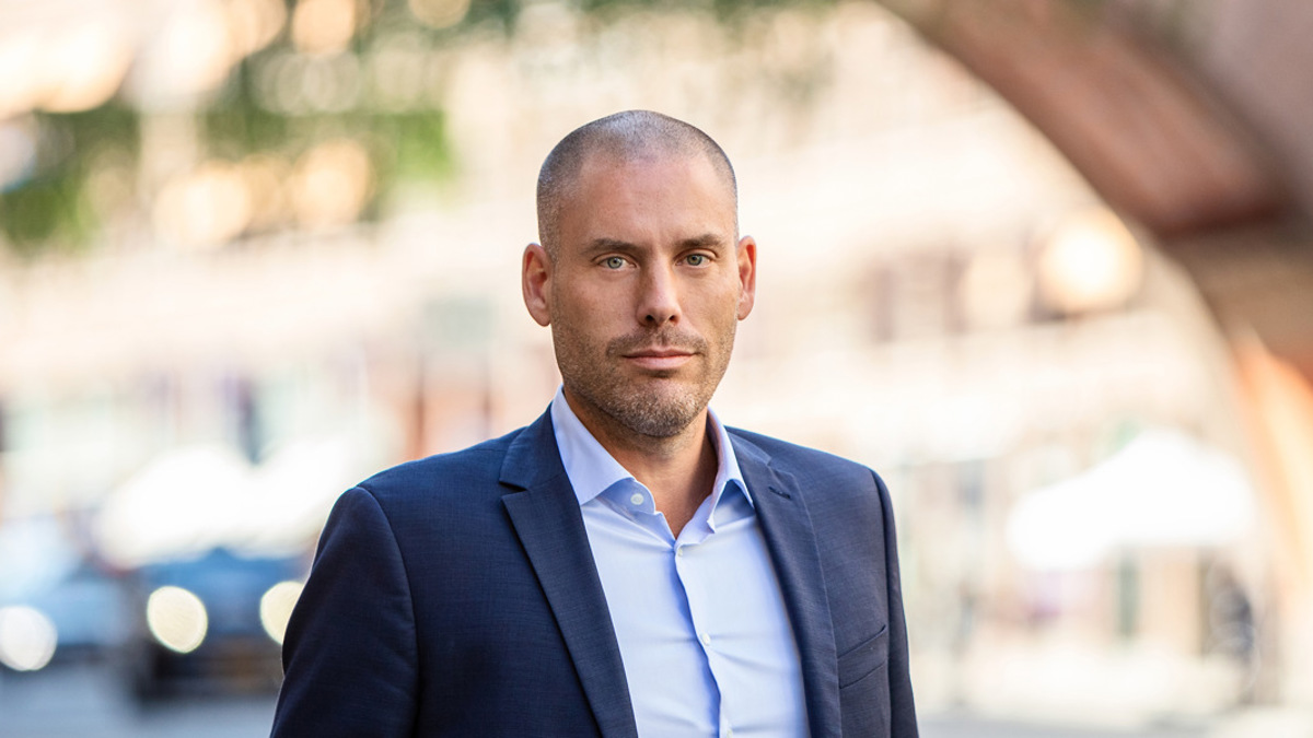 En kostymklädd man går längs gatan.