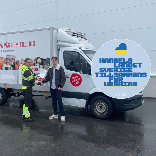 Två män skakar hand framför en lastbil.