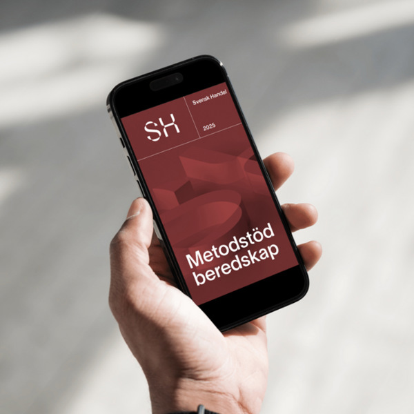 En person som håller en mobiltelefon i handen.