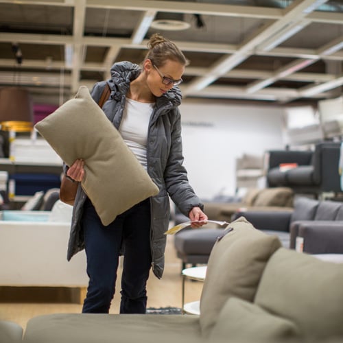 En kvinna tittar på en soffa i en möbelaffär.