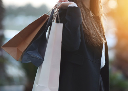 En kvinna med shoppingkassar i händerna.